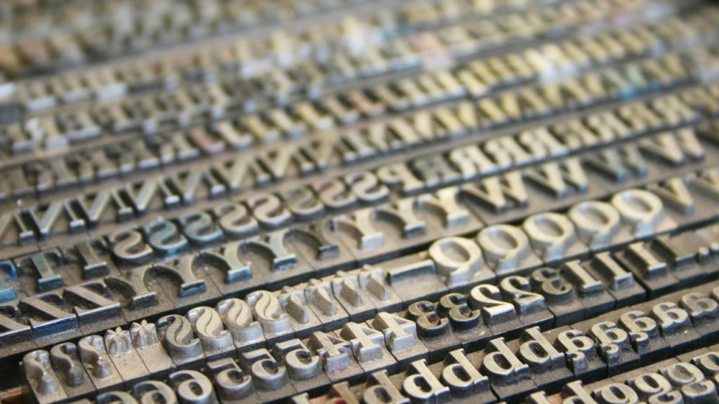Metal stamps of letters and numbers, all in the same font. There are multiples of each letter and number.