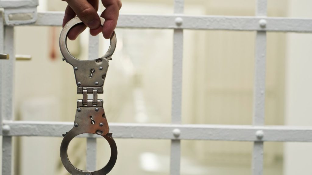 Handcuffs near a jail door.