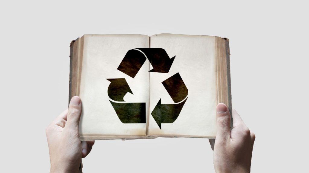 An open book with the logo for recycling on the pages.