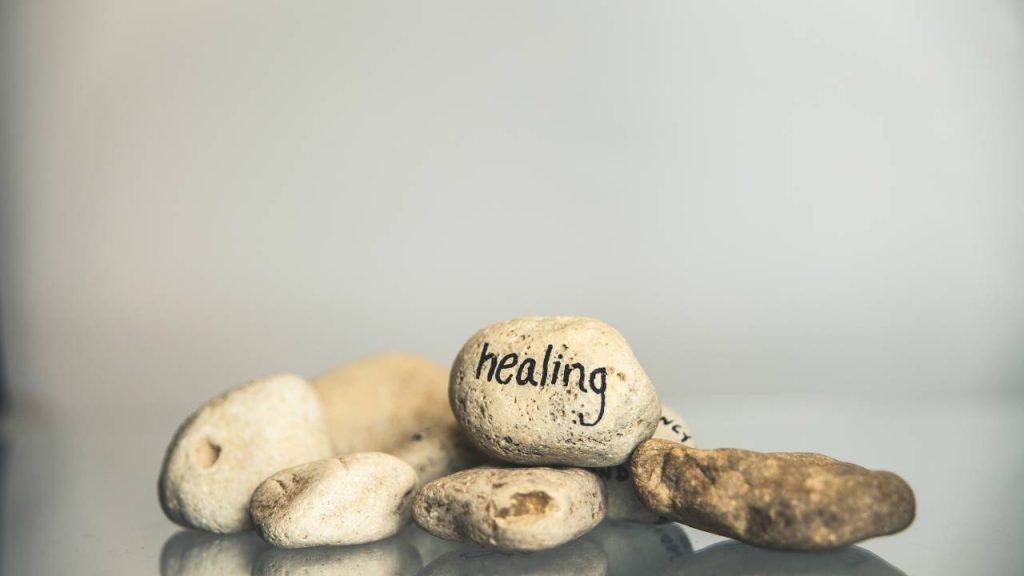A pile of small rocks with healing written on the center rock.