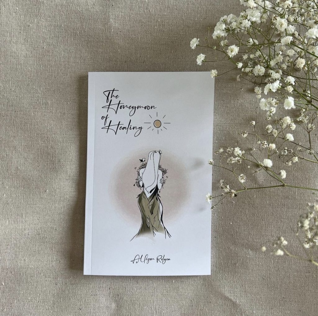 Instagram post of The Honeymoon of Healing book on tan linen next to baby's breath flower.