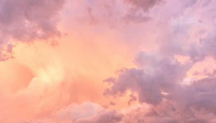 A pink and orange sky with clouds.