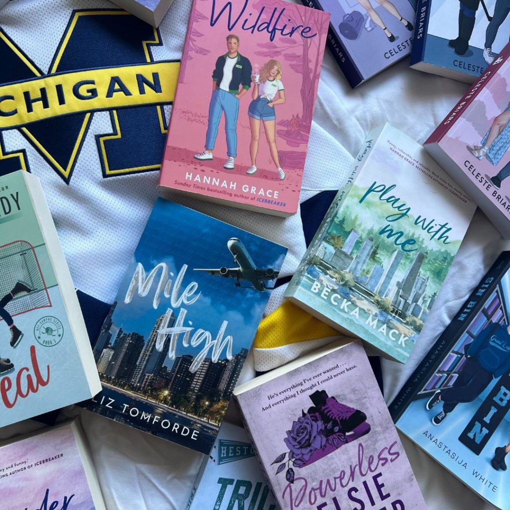 On a Michigan sports jersey, a variety of romance books are aesthetically but haphazardly placed.