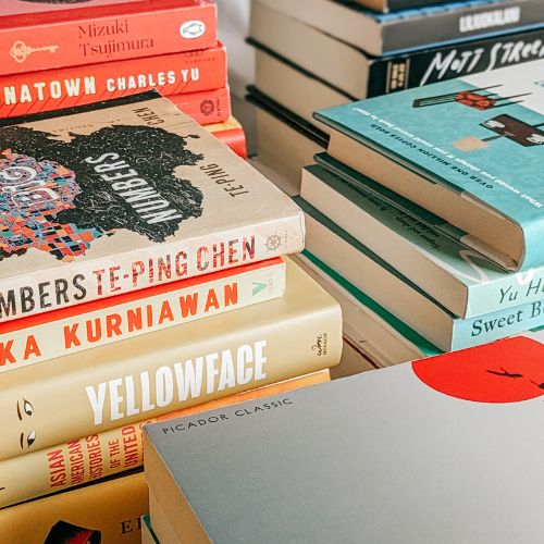 Five stacks of books, sorted by color, taken from a top angle.