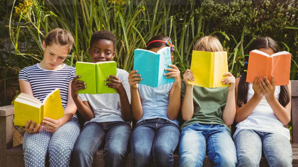 Kids on a bench reading different books.