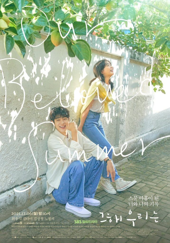 A man and a woman leaning against a wall while they smile and laugh