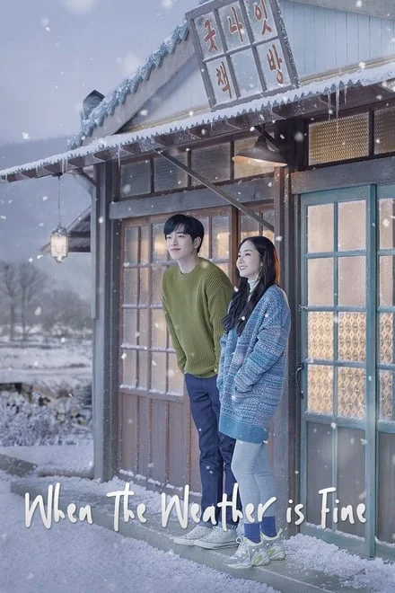 A man in a green shirt next to a woman in a sweater outside in the snow.