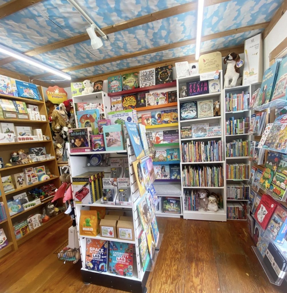 Fairytales Bookstore with shelves of books with a cloud painted ceiling.
