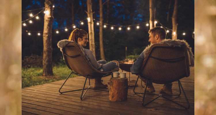 Couple sitting fireside on a summer night.