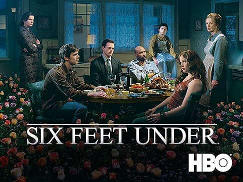Family sitting around a kitchen table with flower arrangements surrounding them.