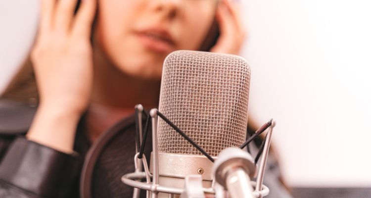 Woman talking into a microphone for audiobooks.
