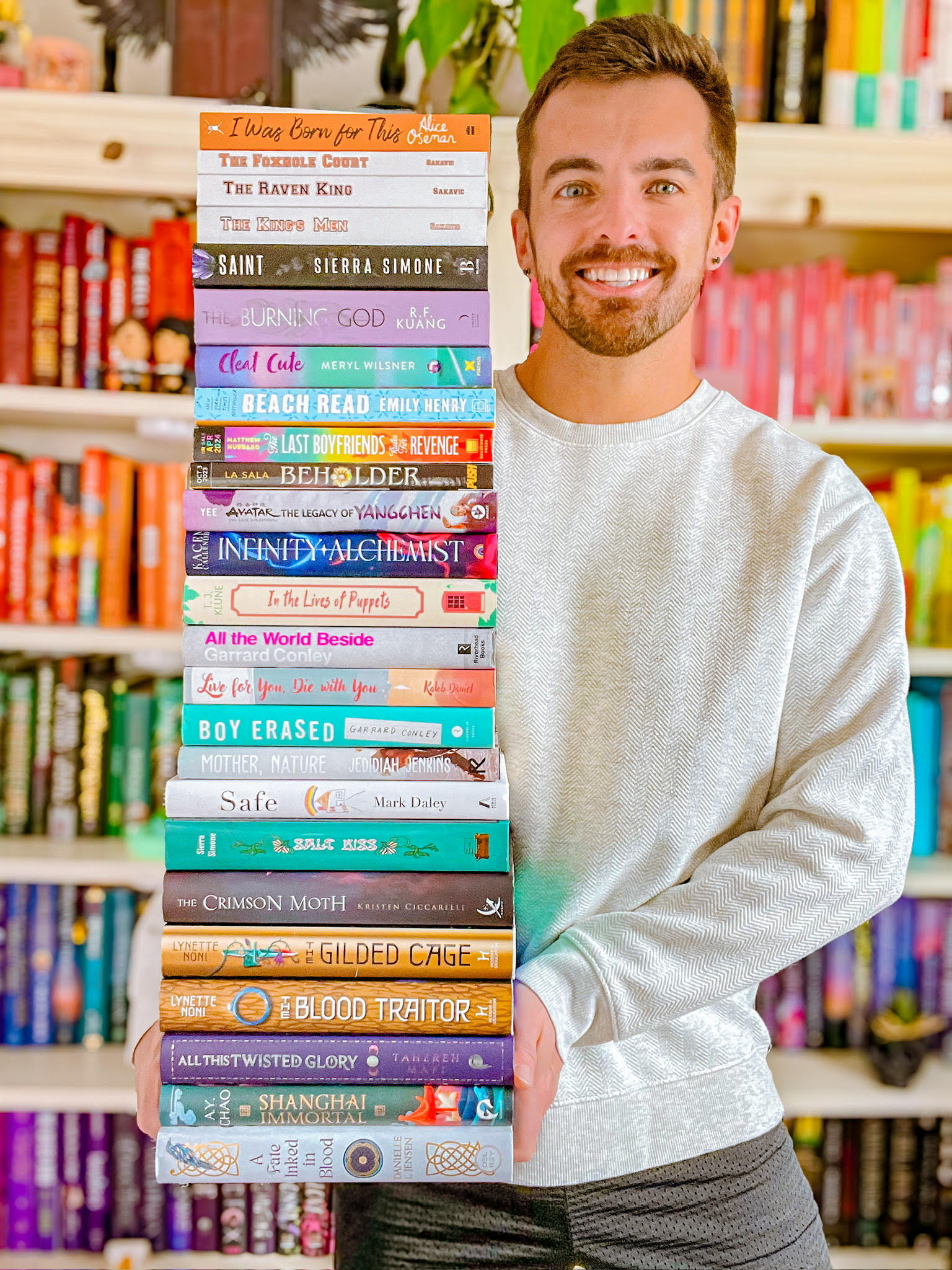 Frank Socha holding a large stack of books.