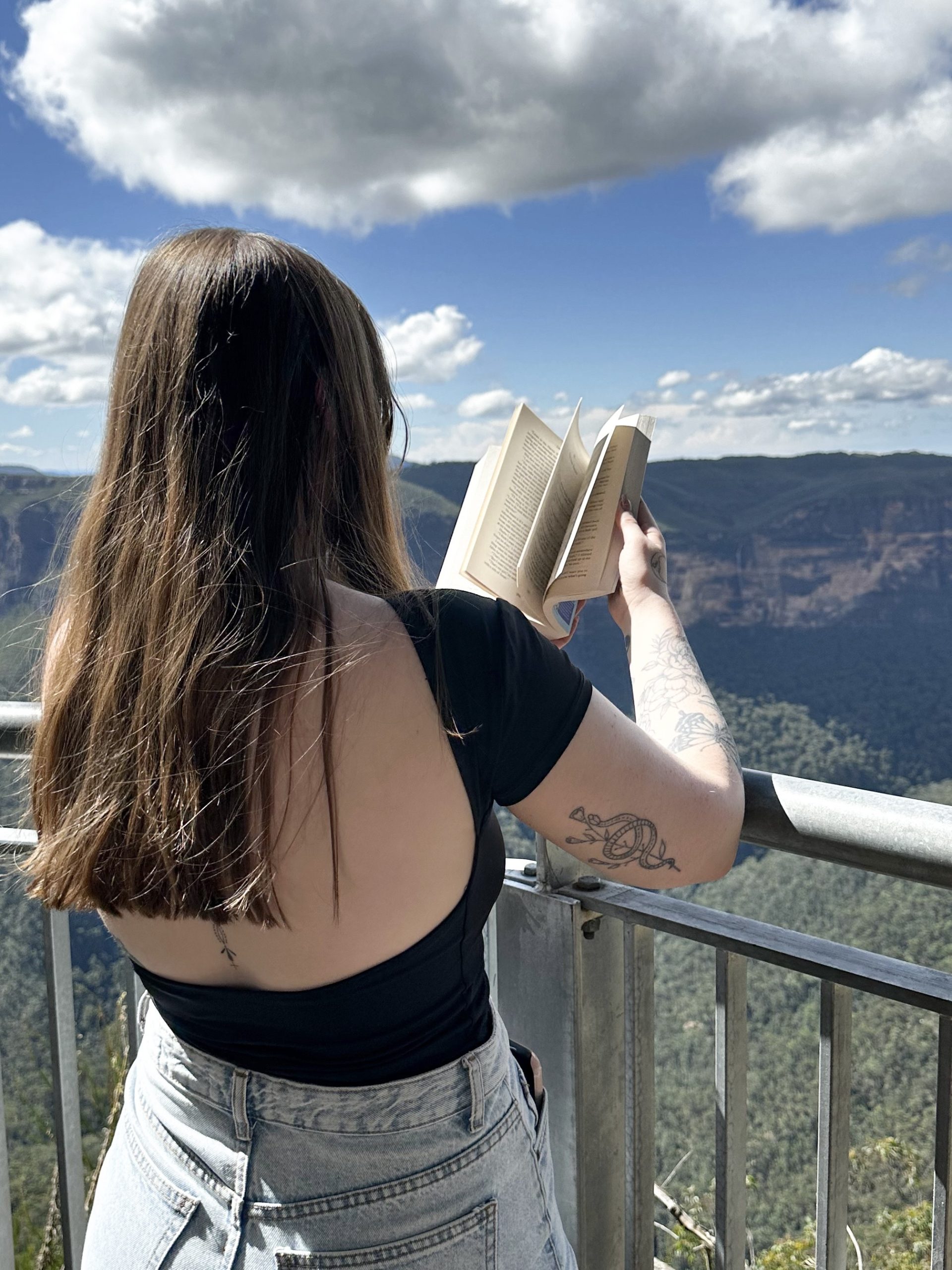 Kaitlyn @kaitlyns_library reading a book with a view.