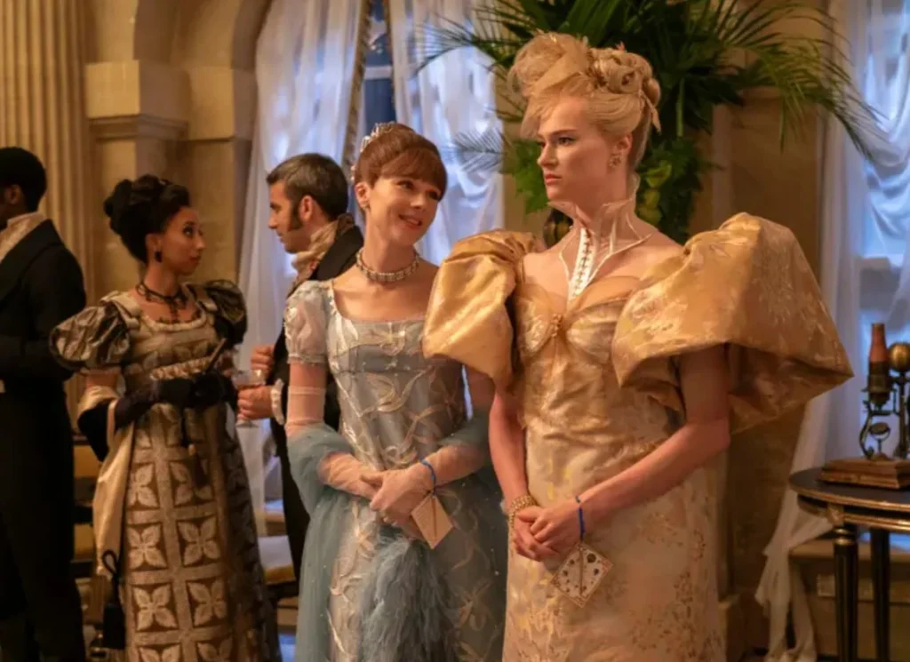 Eloise smiling at Cressida at a ball, both in gowns.
