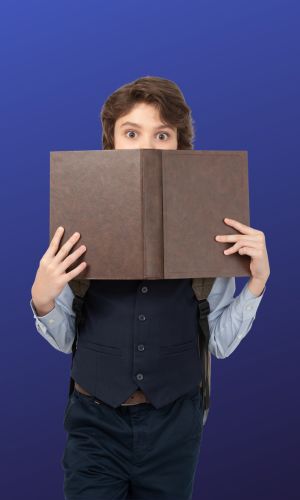 A kid hiding behind a book they were reading.