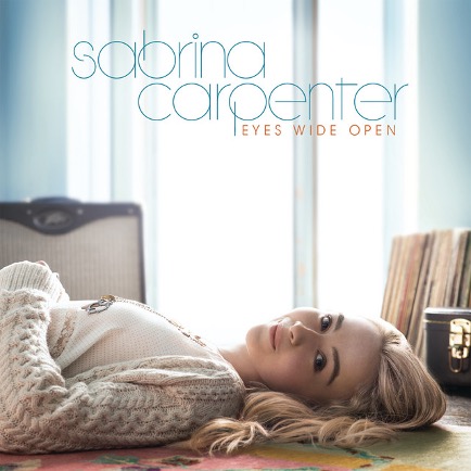 Cover for Sabrina Carpenter's album "Eyes Wide Open" with Sabrina laying down on a table with the windo curtains open.