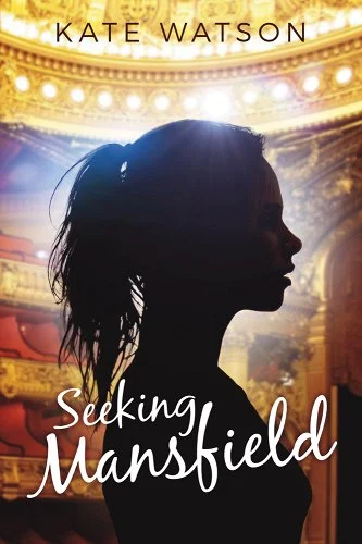 A women's silhouette stands in the forefront of brightly lit theater.