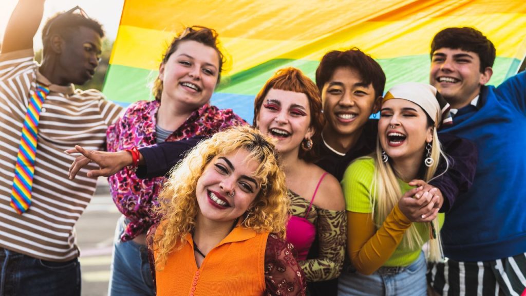group of people holding a pride flag