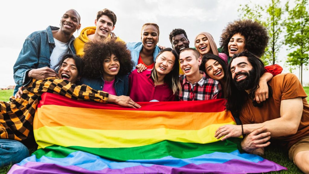 group of people holding a pride flag