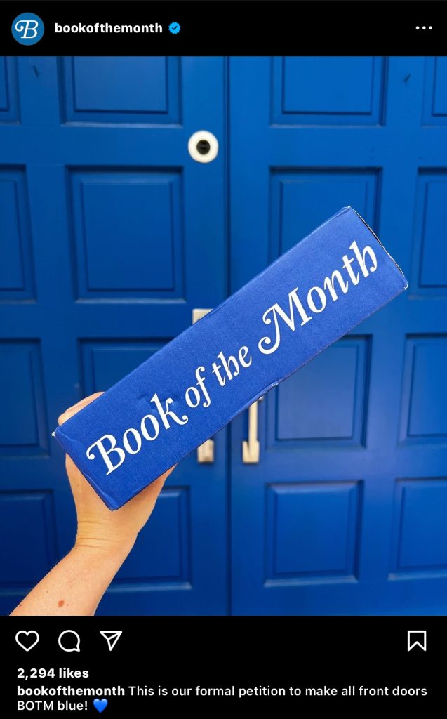 Instagram post by Book of the Month holding a blue book of the month box in front of a blue front door.