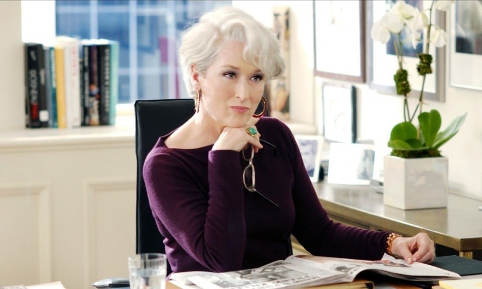 Miranda Priestly staring off with her hand under her chin.