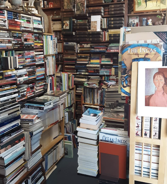 Piles of books stacked to the ceiling in Footnote Books store