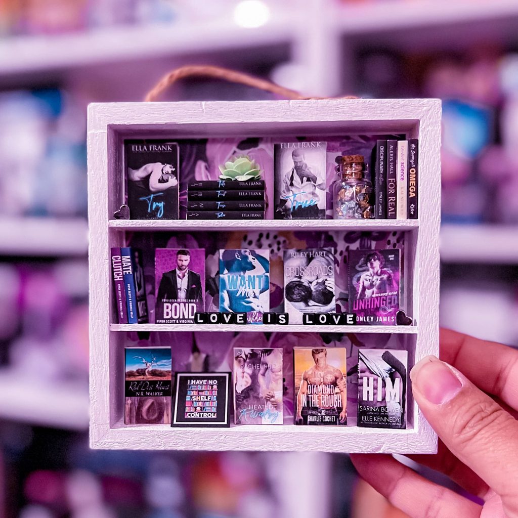 Miniature bookshelf featuring a variety of titles and the words "Love is Love"