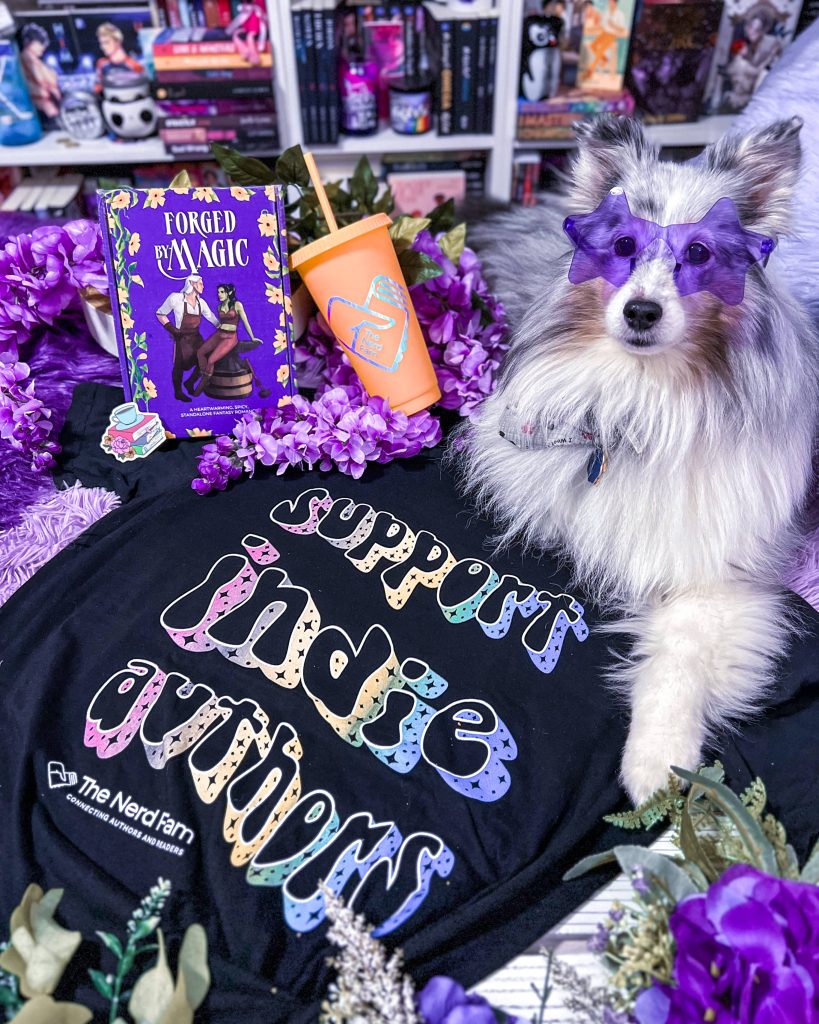 Collie dog wearing purple star sunglasses sitting next to a shirt that says support indie authors in a bubbly font.