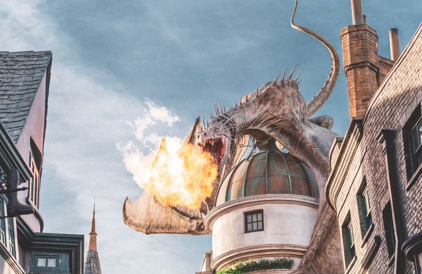 A dragon perched on a building and breathing fire