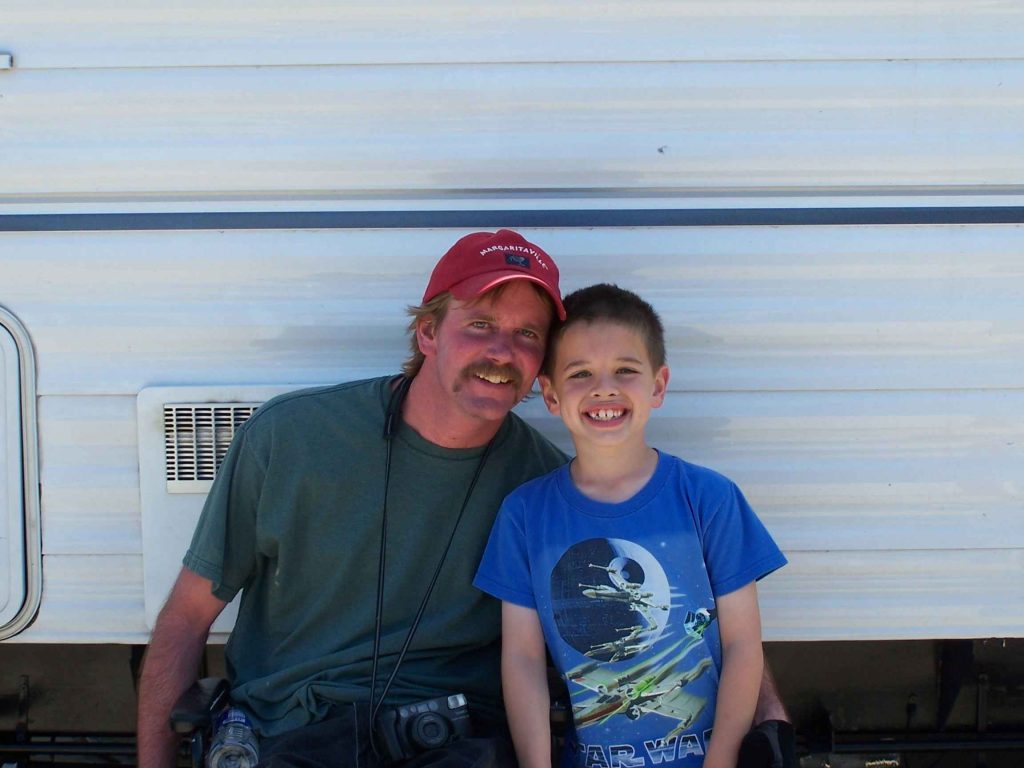Father and son smiling in front of a white background.