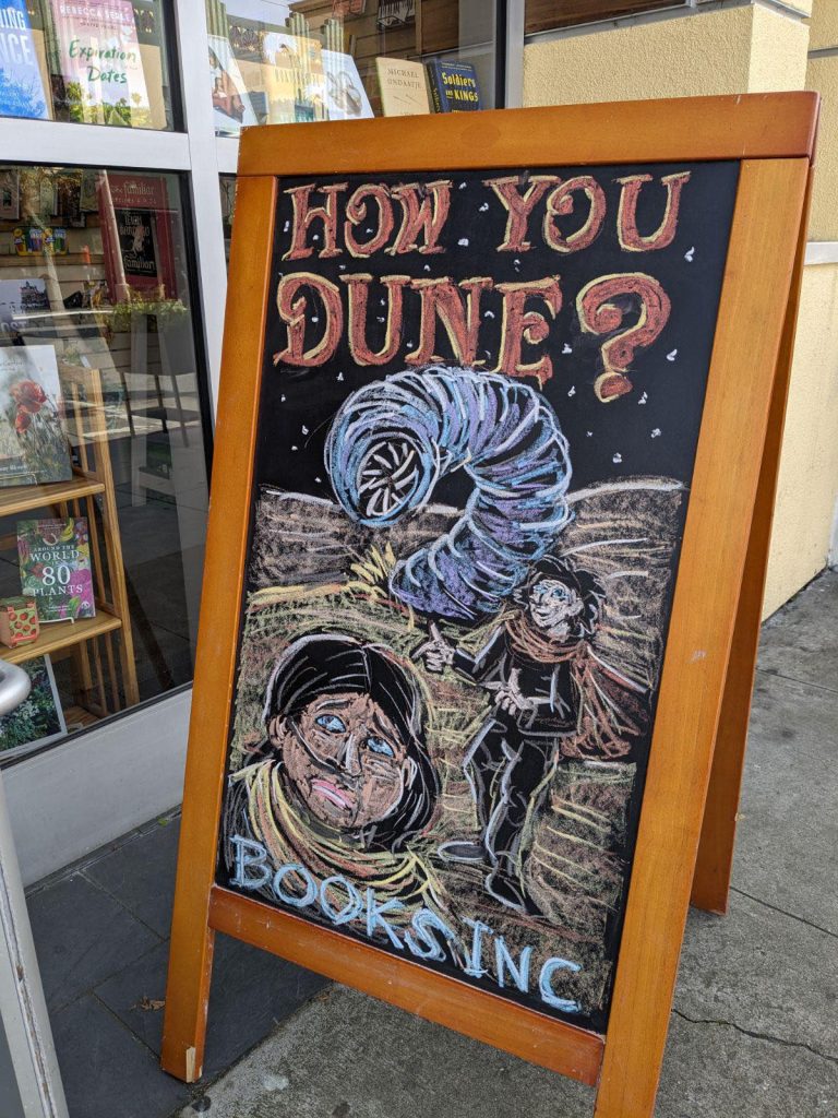 Chalk sign at Books Inc. depicting a scene from Frank Herbert's Dune along with the caption "How you Dune?"