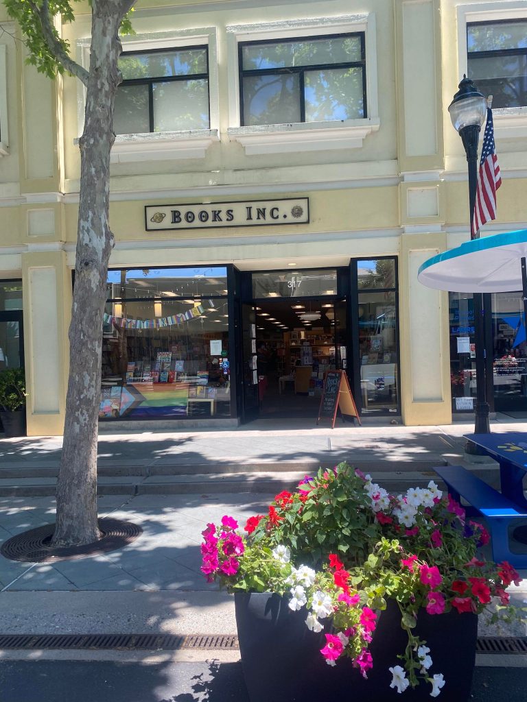 The Books Inc. storefront. A yellow building with a black sign reading "Books Inc."