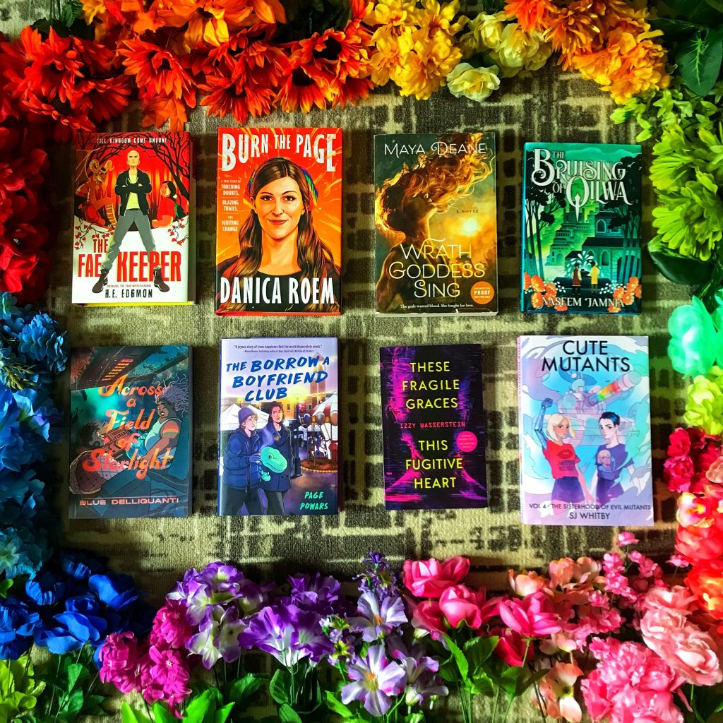 Eight book covers, lined up in two rows, surrounded by rainbow-colored flowers.