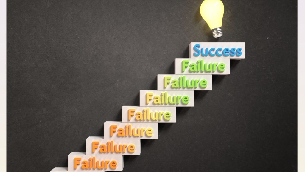 Stairs that say failure on each step until you get to the top where is states success with a lit lightbulb
