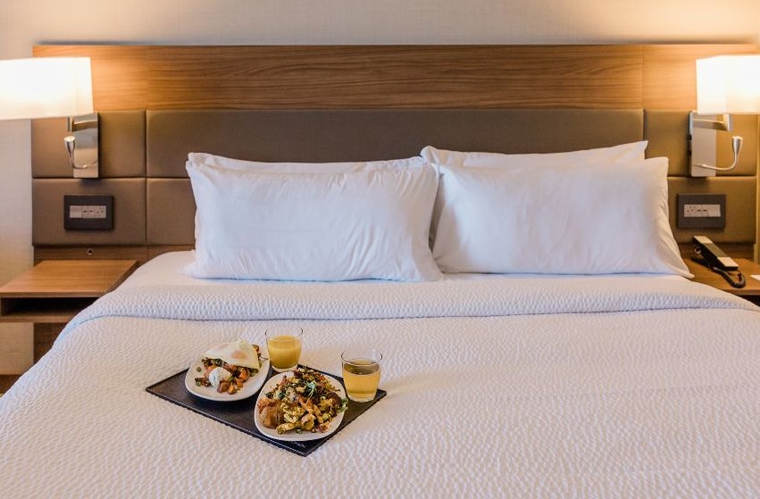 A tray with two breakfasts sitting on a bed
