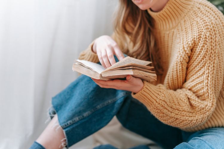 A person reading an old looking book.