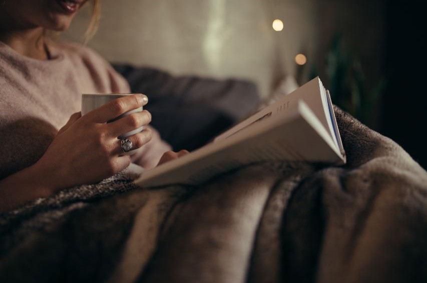 Someone curled up with a book and a drink.