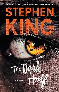 Book cover for The Dark Half by Stephen King. Shows a close up of an orange colored eye, with the silhouette of birds in it.