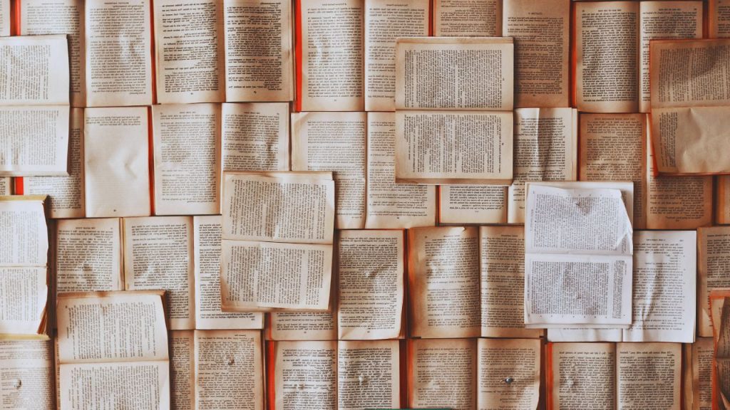 A large collage of open books lying across one another.