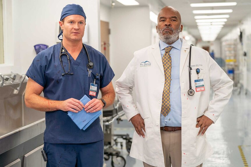 Josh Lawson and David Alan Grier stare at something out of sight of the camera.