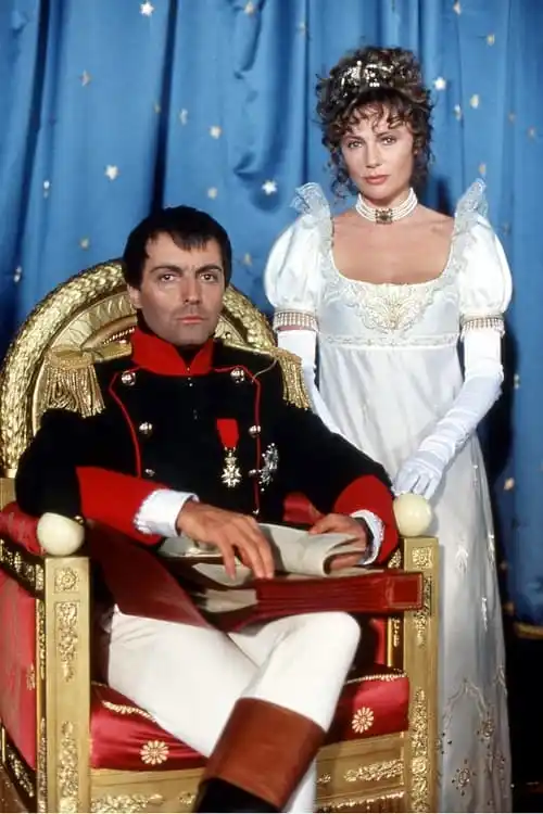 Napoleon Bonaparte sitting in a throne with his wife Josephine standing by him.