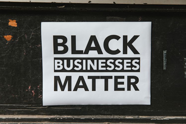 Sign with the words black businesses matter against a black background