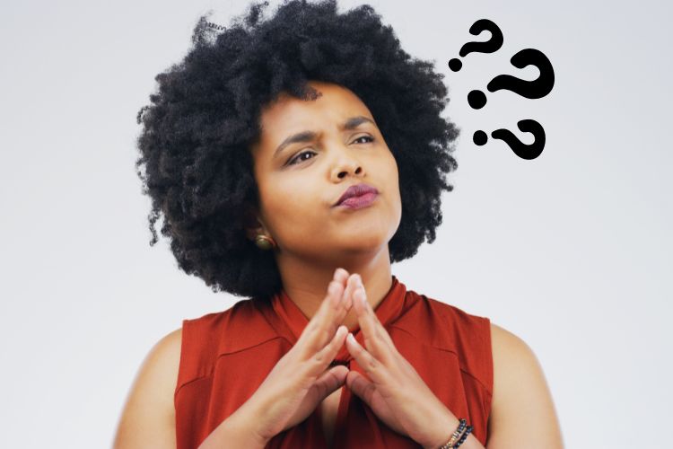 Black woman in a red blouse, looking thoughtfully into the distance with question marks beside her head, suggesting deep contemplation. Her hands are positioned in a prayer-like pose in front of her, adding a sense of introspection to the scene.