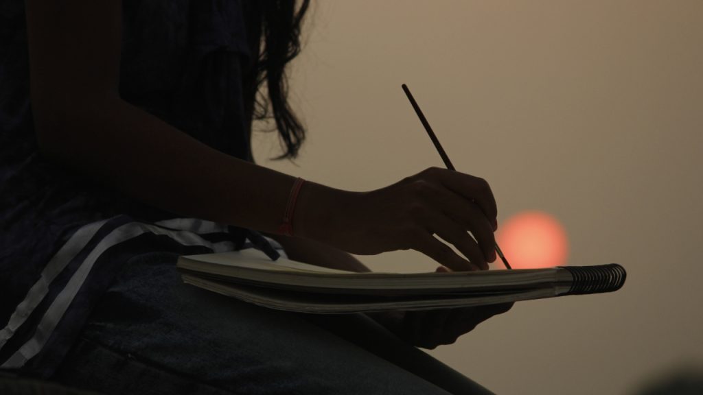 woman painting on a notebook