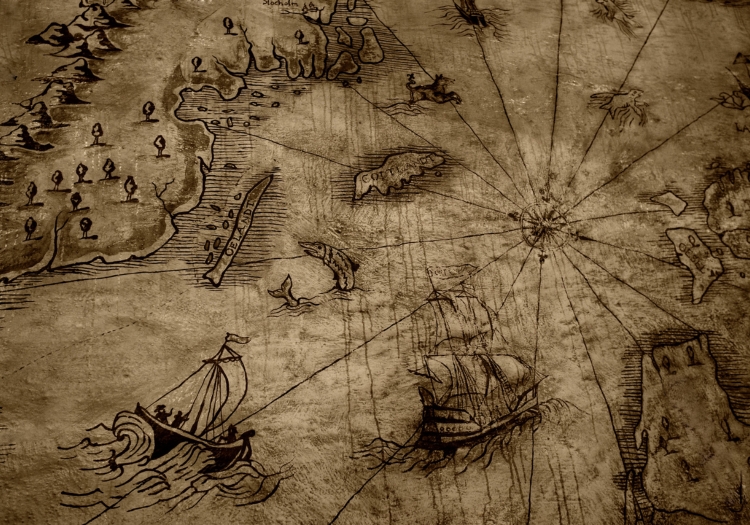 Old faded map, with two sailboats, fish, a compass, and land with trees and mountains drawn on it.