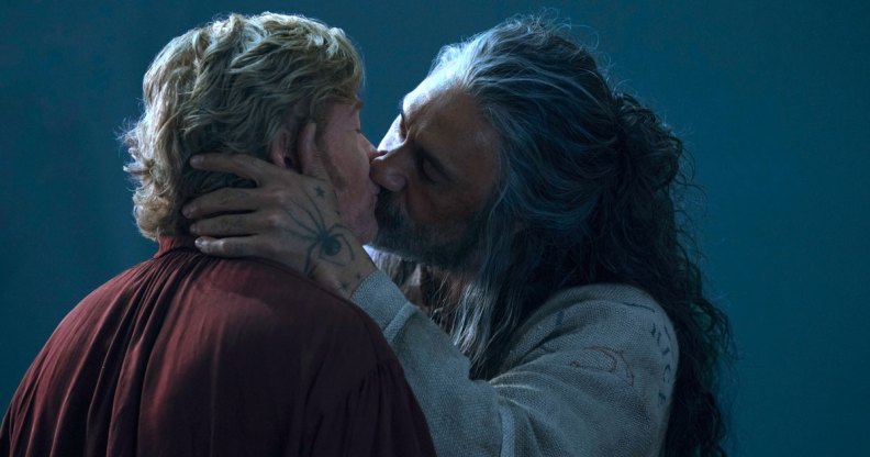 Stede and Ed kissing. Ed's hand, which is tattooed with a large spider, rests on the back of Stede's neck.