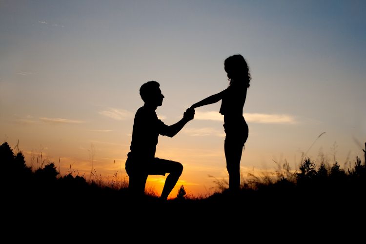 There are two shadows, a man on one knee proposing to a woman.