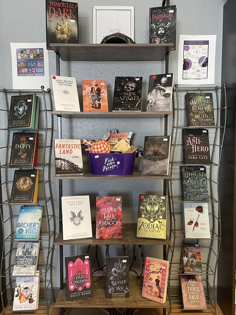 A bookshelf full of fiction novels is on display.