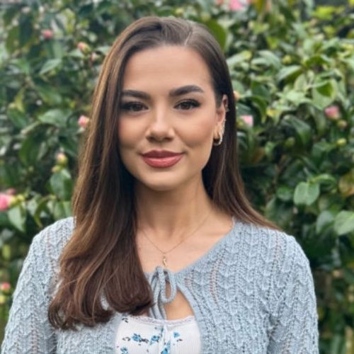 Profile image of Imani Erriu outside before flowered bushes.