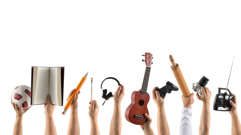 Several sets of hands holding up different types of activities against a white background.